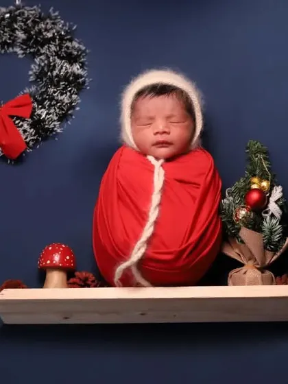 Jingle bells! This newborn is wrapped up like a little Christmas present on a shelf. A simple and adorable holiday idea.