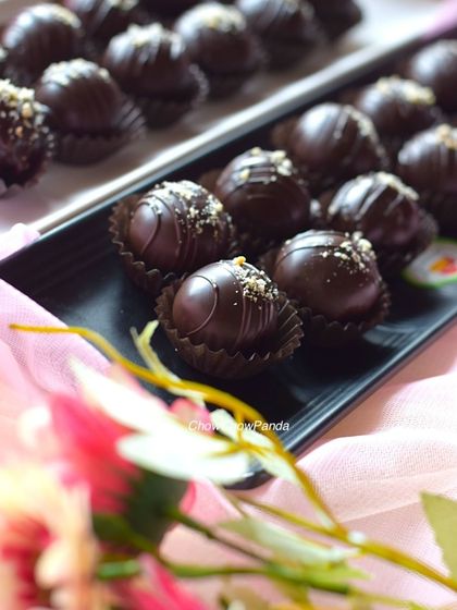 A detailed close-up of the dark chocolate cake pops. You can see the texture from the drizzled chocolate and the fine gold dust on top.