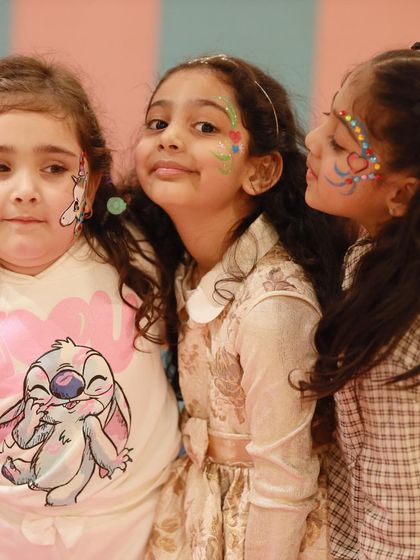 Girls showing off their beautiful face paint. This is a wonderful way for kids to express themselves and get into the party spirit.
