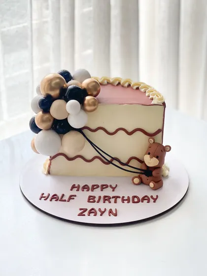 Half birthdays deserve full celebrations! This half-slice cake is decorated with a balloon cascade and a cute teddy bear for Zayn's 6-month milestone.