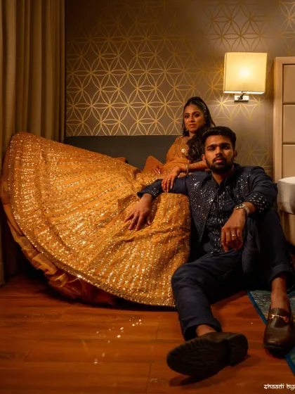 A stylish, editorial-style Sangeet portrait. The pose is confident and modern, highlighting the couple's fashionable outfits.