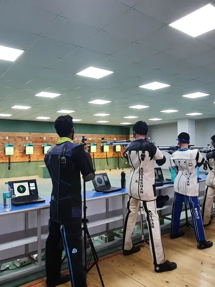 Another angle of our shooters during a competitive practice. The use of professional shooting jackets and equipment is standard for our advanced athletes to ensure proper form and stability.