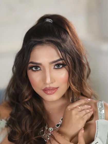 A close-up portrait of a model with a fresh and flawless makeup look. The glossy lips and sharp winged liner create a modern and glamorous vibe.