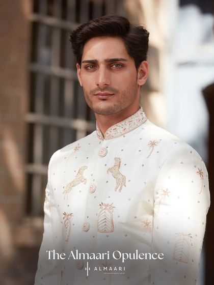 A direct, confident portrait showcasing the elegance of this embroidered ivory sherwani. The fit and the fine details on the collar and buttons are designed to make you look your absolute best.