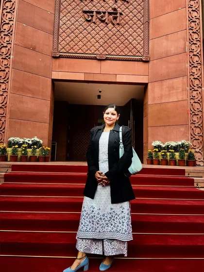 A formal ethnic look for a visit to the Indian Parliament, featuring a printed palazzo set layered with a smart black blazer.