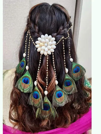 A captivating hairstyle using a custom accessory made of shells and peacock feathers, perfect for a Mehendi or Haldi look.