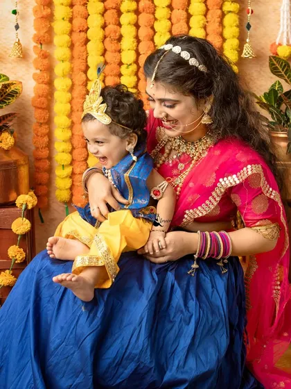 A candid moment of laughter between a mother and her little Krishna. These unposed shots are often the most cherished.