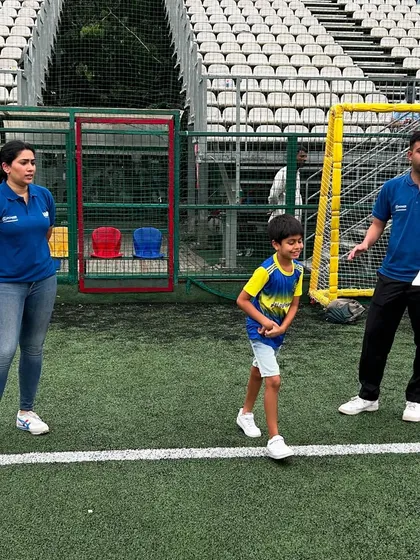 A young player participates actively in a mental conditioning workshop on the field, flanked by two experts. This interactive approach helps our players build confidence and mental toughness.