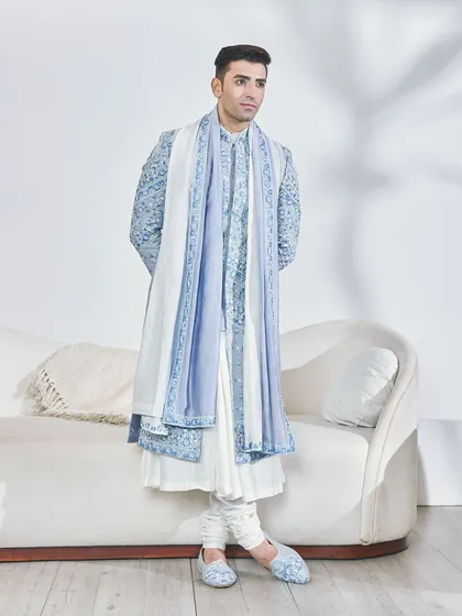 The elegance of the powder blue sherwani in a relaxed pose. The matching embroidered mojris show my commitment to a fully styled, head-to-toe look.