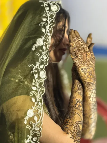 A side profile of a bride with her elegant Dubai-style mehendi, showing how the design gracefully covers her hands and arms.