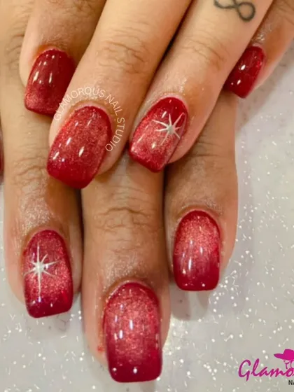 A dramatic and glamorous look, these nails feature a deep red cat-eye effect with a sparkling starburst on the accent nails.