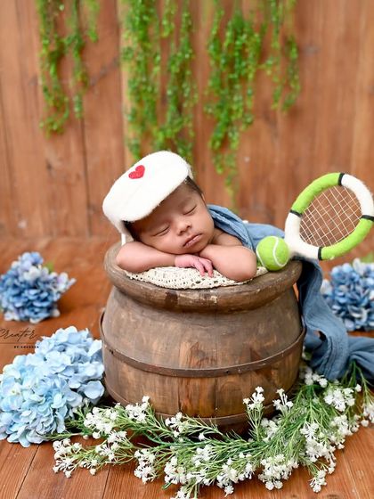 Our little tennis star is resting up for the big game. This variation of the tennis theme showcases the classic 'chin-on-hands' pose.