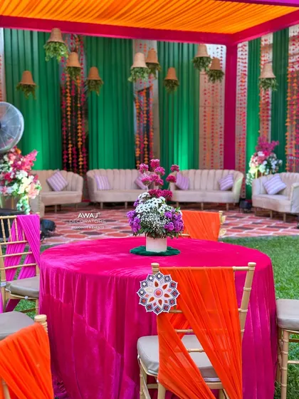 A guest table at the Mehendi, with a bright pink tablecloth and vibrant chair ties, continuing the joyful color scheme.
