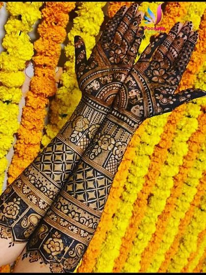 Full bridal arms set against a backdrop of marigold flowers, perfectly capturing the festive spirit of an Indian wedding. The design features traditional bands and patterns.