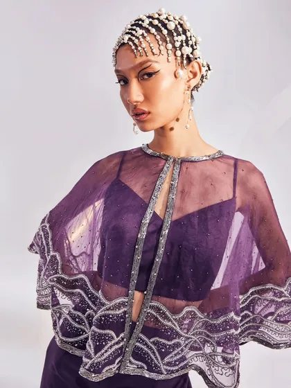 The Zoey Cape Set is your go-to for effortless glam. I designed this lightweight, embellished organza cape to be paired with a bold bustier and fluid trousers.
