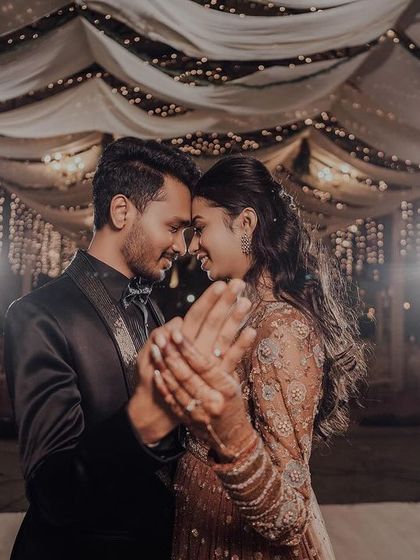 The couple sharing a dance at their reception under a beautifully decorated ceiling.