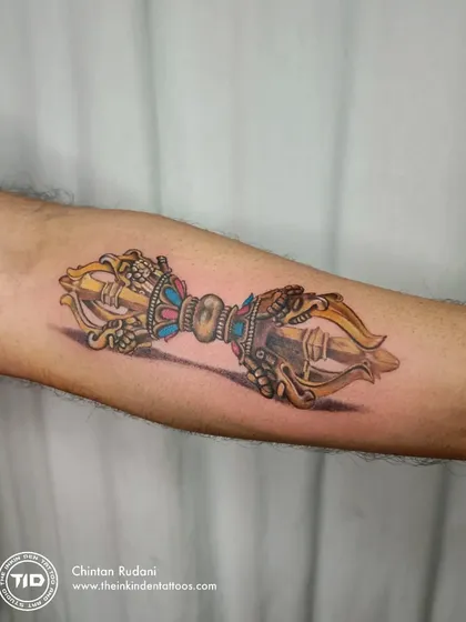 A hyper-realistic color tattoo of a Dorje, a Tibetan Buddhist symbol for indestructibility and irresistible force. The intricate details and 3D effect make this piece a powerful emblem of spiritual strength.