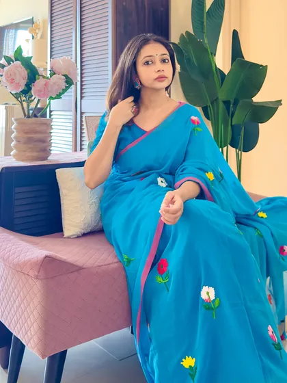 A seated pose on a bench, showing how this saree can be styled for a day out. It's casual, comfortable, and chic.