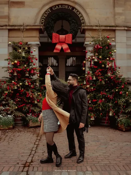A joyful twirl at Covent Garden Market, surrounded by Christmas cheer. This London pre-wedding shoot was filled with the magic of the holiday season.