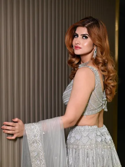 Sangeet glam with a silver-grey lehenga. The makeup is cool-toned and shimmery, with a bold red lip that adds a pop of color and drama.