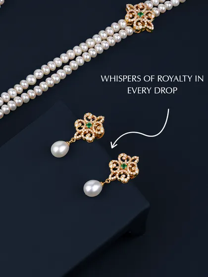Whispers of royalty in every drop. These matching earrings, part of a larger heirloom set, feature delicate goldwork, a central emerald, and a single pearl drop. They are designed to be worn together with the necklace or on their own for a touch of understated elegance.