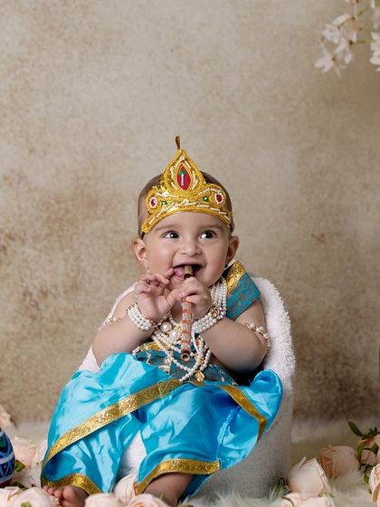 This little Krishna is captured in a moment of pure, uninhibited joy. These candid shots are often the family's favorites.