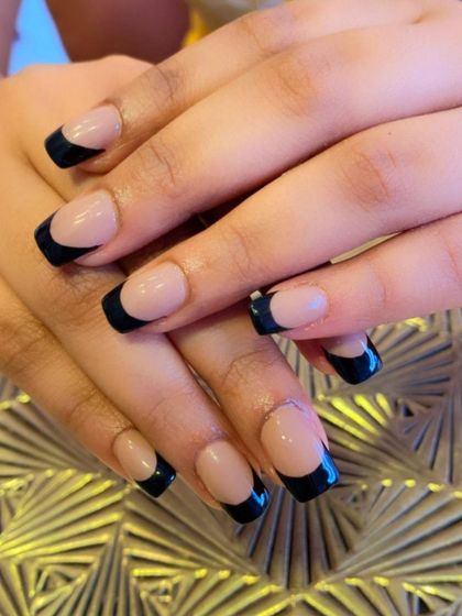 A minimalist and modern take on the French manicure. These square-shaped nails feature a nude base with a very thin, crisp black line at the tips.