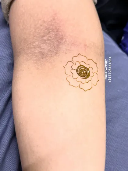 A tiny, simple spiral rose motif. This is a great option for kids or for guests who want the smallest touch of henna.