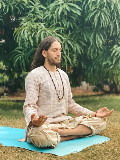 This is a duplicate of image 199. A student finds a quiet spot in nature for meditation, connecting with the peaceful energy of the ashram grounds.