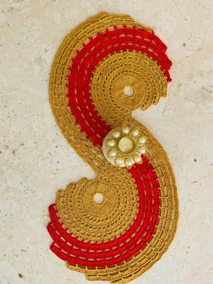 The gold and red spiral runner styled with a decorative candle holder, perfect for a festive setup.