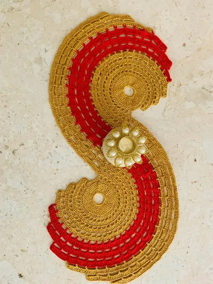 The gold and red spiral runner styled with a decorative candle holder, perfect for a festive setup.