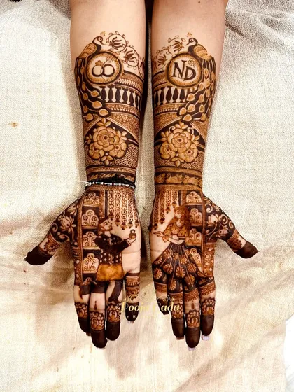 The complete view of a personalized engagement mehendi. Both hands tell a story with figures, initials, and symbols of love, creating a design that is truly one of a kind.