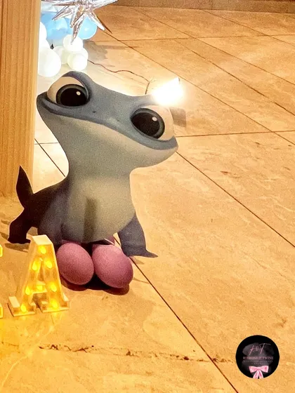 A charming cutout of Bruni the salamander from Frozen 2, placed near the personalized marquee letters, adding another layer of detail to the theme.