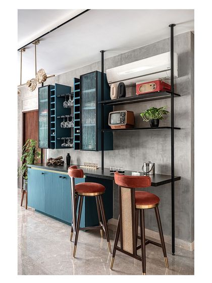 We designed this custom bar unit in a striking teal color to be a central gathering spot in the home. The open shelving and integrated racks provide a stylish space to display the clients' antique collections and glassware.