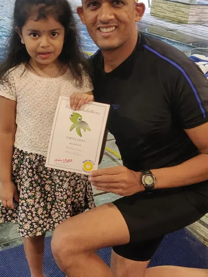 Posing with a young swimmer and her well-earned certificate. I make sure every child feels recognized for their hard work and achievement in my beginner swim classes.