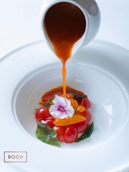 The dramatic pour of our Cherry Tomato Rasam. This tableside presentation enhances the dining experience, releasing the beautiful aroma of the soup.