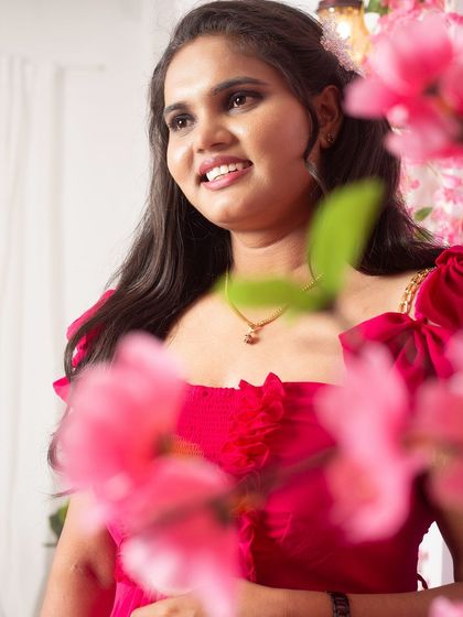 A beautiful close-up shot that captures the happy expression of a bride-to-be. The floral elements of the set create a soft, romantic frame for portraits like this.
