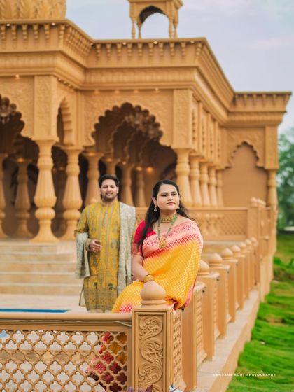 Dressed in elegant ethnic wear, this couple's pre-wedding shoot at a heritage location combines tradition with grandeur. The intricate architecture provides a timeless backdrop for their portraits.