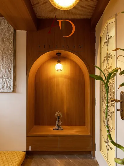 An arched wooden niche with a simple pendant light creates a perfect, peaceful spot for a Buddha idol, adding to the room's calm atmosphere.
