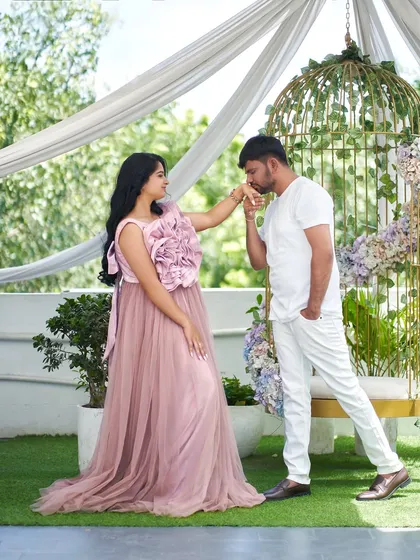 A classic, chivalrous pose that looks straight out of a storybook. The soft pink of the 'Bloom' gown adds to the romantic atmosphere of this maternity shoot.