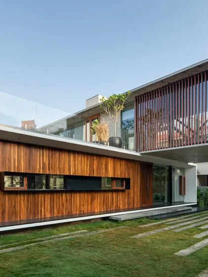A perspective showcasing the 24-foot cantilever, a signature element of the Long House. This bold structural expression is balanced by the warmth of the wood-clad lower level and its integration with the landscaped lawn.