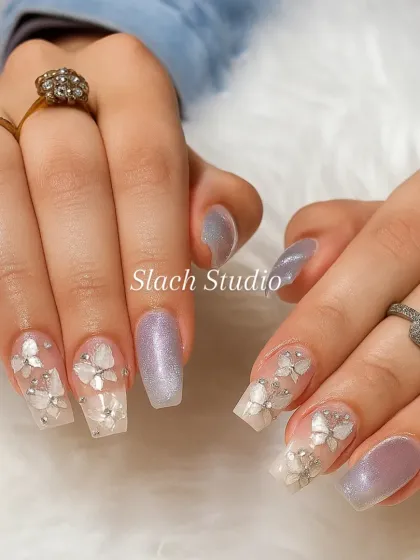 This shows the intricate 3D work I love to do. On these coffin-shaped extensions, I paired a pearlescent lilac shimmer with translucent nails adorned with delicate, hand-sculpted white flowers and rhinestone centers.