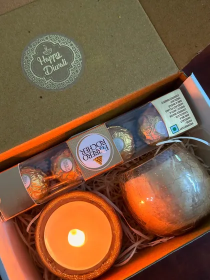 The lit version of our mini hamper, showing the cozy ambiance it creates. We also include a Diwali message card in each box.