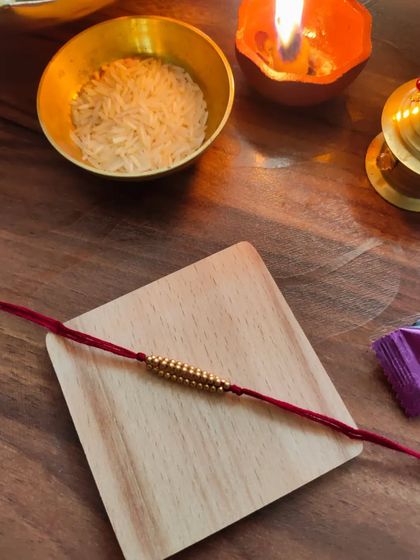 My most affordable rakhi design, priced at 20 rupees. This simple yet beautiful rakhi is made with golden beads on a red thread.