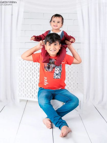 A playful moment between brothers, with the younger one enjoying a ride on his big brother's shoulders. A photo full of fun and energy.