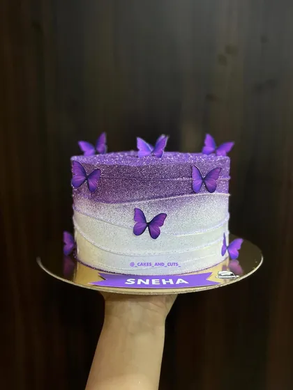A hand-held shot of the glittering purple butterfly cake.