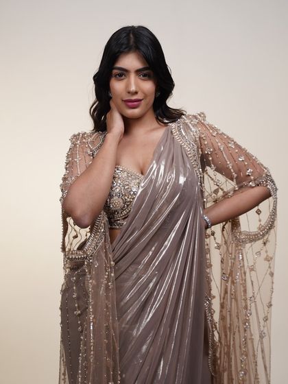 A close-up of the metallic pre-draped saree with its sheer cape, showing the delicate embroidery and beadwork.