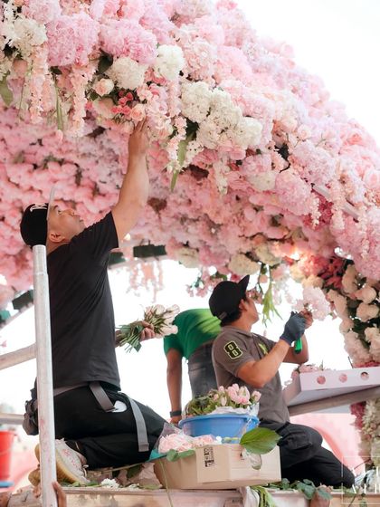 A behind-the-scenes shot of our talented artisans meticulously placing flowers on the 'Echoes of Pink' mandap. It takes a village to bring these dreams to life.