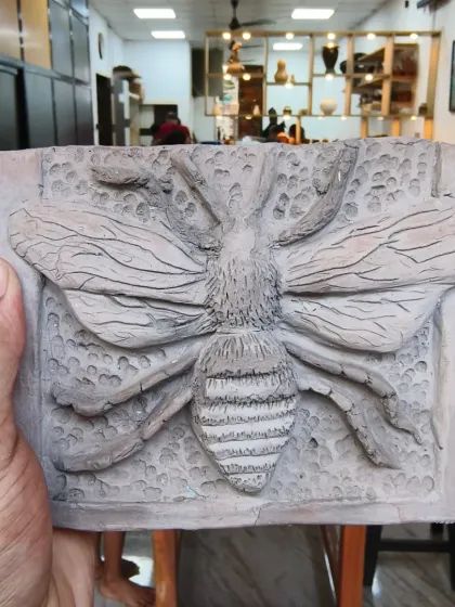 Another stunning fossil mural from our workshop, this time featuring a detailed bee. Students learn to work with clay to create raised relief sculptures and textured backgrounds for unique wall art.