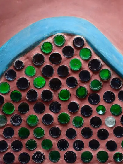 This is our bottle wall at Cheerville, a perfect example of turning waste into beauty. Using recycled glass bottles as masonry units, we created a functional wall that allows colorful, patterned light to filter through, adding a playful and sustainable touch.